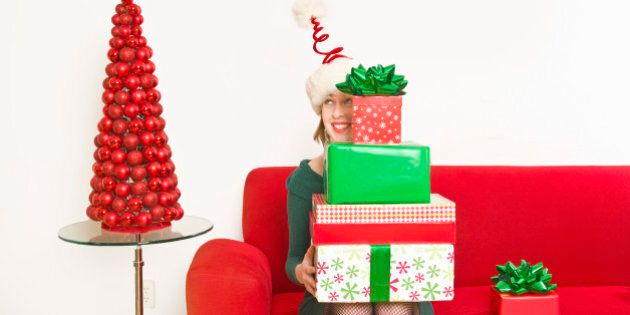Woman holding stack of Christmas gifts