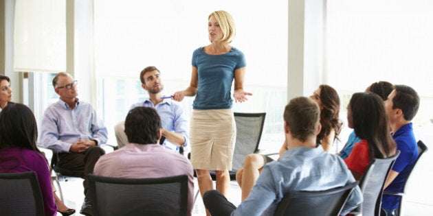 Businesswoman Addressing Multi-Cultural Office Staff Meeting In Smart/Casual Dresswear