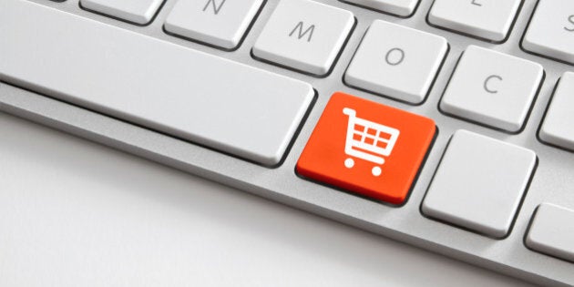 Online shopping concepts shooting of white computer keyboard with orange shopping cart button.