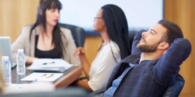 Businessman leaning back in boardroom