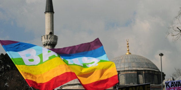 Turkish gay rights group (LAMBDA) activists wave peace flags infront of a mosque in Istanbul on March 16, 2010 during a demonstration against Family Affairs Minister Aliye Selma Kavaf. Some 60 activists denounced Kavaf and called for her resignation, as they accuse the Family Affairs Minister of insult, incitement to crime and incitement to enmity and hate -- crimes which are punishable by up to two, five and three years in jail respectively. Kavaf, who is also women's minister in the Islamist-rooted government, said in a newspaper interview last weekend that she believed homosexuality was a 'biological disorder, a disease.' AFP PHOTO / MUSTAFA OZER (Photo credit should read MUSTAFA OZER/AFP/Getty Images)