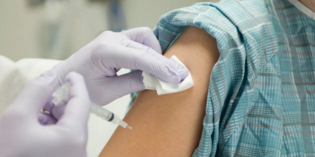 Doctor placing gauze on patient's arm after administering a shot