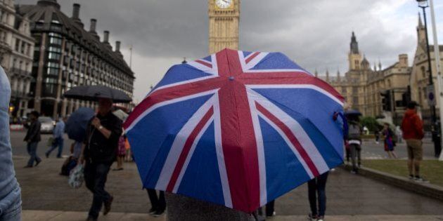 TOPSHOT - A pedestrian shelters from the rain beneath a Union flag themed umbrella as they walk near the Big Ben clock face and the Elizabeth Tower at the Houses of Parliament in central London on June 25, 2016, following the pro-Brexit result of the UK's EU referendum vote.The result of Britain's June 23 referendum vote to leave the European Union (EU) has pitted parents against children, cities against rural areas, north against south and university graduates against those with fewer qualifications. London, Scotland and Northern Ireland voted to remain in the EU but Wales and large swathes of England, particularly former industrial hubs in the north with many disaffected workers, backed a Brexit. / AFP / JUSTIN TALLIS (Photo credit should read JUSTIN TALLIS/AFP/Getty Images)