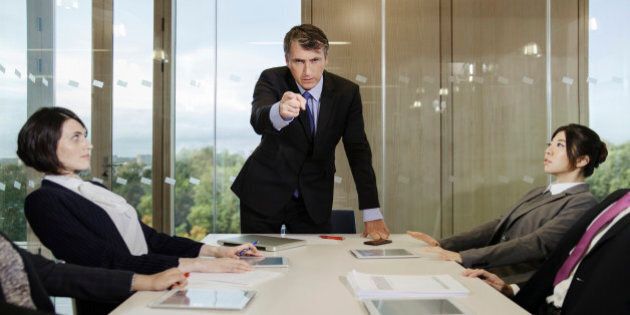Businessman pointing finger in meeting at office conference room table