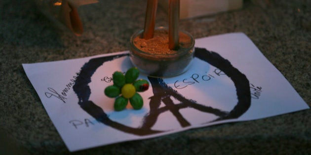 Candles are put on a peace sign combined with the Eiffel Tower at a temporary memorial for the victims of the Paris attacks in Rennes, western France, Saturday, Nov. 14, 2015. French President Francois Hollande vowed to attack the Islamic State group without mercy as the jihadist group claimed responsibility Saturday for orchestrating the deadliest attacks on France since World War II. (AP Photo/David Vincent)