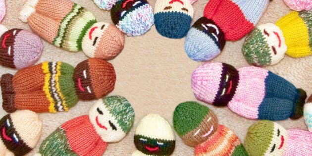 Knit toy children dolls with many colors of multiculturalism within the faces.