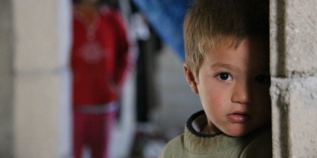 HATAY, TURKEY - NOVEMBER 21: A Syrian refugee kid fled from his home due to civil war is seen at a house in Reyhanli district of Hatay on November 21, 2015. Syrian refugee families who fled their country due to the ongoing civil war try to hold on to life as they live in rented houses, tents and storehouses. (Photo by Cem Genco/Anadolu Agency/Getty Images)