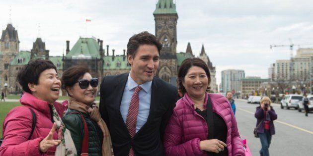 Canadian Liberal Party leader Justin Trudeau poses for a selfie with tourists as he walks from the parliament to give a press conference in Ottawa on October 20, 2015 after winning the general elections. AFP PHOTO/NICHOLAS KAMM (Photo credit should read NICHOLAS KAMM/AFP/Getty Images)