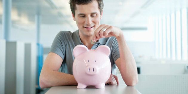 Businessman inserting a coin into a piggy bank