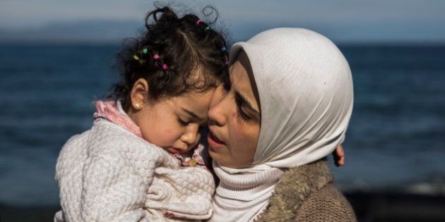 A Syrian mother hugs her child after they arrived from Turkey at the Greek island of Lesbos on an overcrowded inflatable boat , Tuesday, Oct. 27, 2015. Greeceâs government says it is preparing a rent-assistance program to cope with a growing number of refugees, who face the oncoming winter and mounting resistance in Europe. (AP Photo/Santi Palacios)