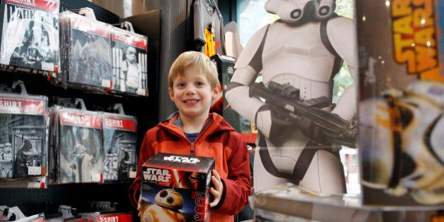 PARIS, FRANCE - NOVEMBER 04: A kid shows a box of Sphero BB-8 Star Wars droid for sale at La Grande Recre' store on November 4, 2015 in Paris, France. The merchandise is on sale ahead of the December 16 release of the 'Star Wars Episode VII : The Force Awakens' in Paris. (Photo by Chesnot/Getty Images)