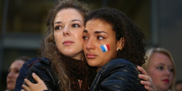 SYDNEY, AUSTRALIA - NOVEMBER 14: Two woman embrace as Australians hold a vigil for victims of the Paris terror attacks at Martin Place on November 14, 2015 in Sydney, Australia. At least 120 people have been killed and over 200 injured, 80 of which seriously, following a series of terrorist attacks in the French capital. (Photo by Daniel Munoz/Getty Images)