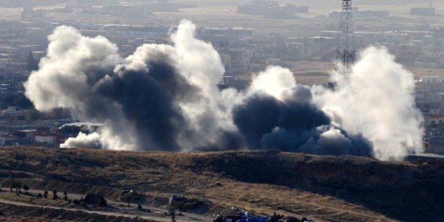 Smoke billows from the northern Iraqi town of Sinjar during an operation by Iraqi Kurdish forces backed by US-led strikes on November 12, 2015, to retake the town from the Islamic State group and cut a key supply line to Syria. The autonomous Kurdish region's security council said up to 7,500 Kurdish fighters would take part in the operation, which aims to retake Sinjar 'and establish a significant buffer zone to protect the (town) and its inhabitants from incoming artillery.' AFP PHOTO / SAFIN HAMED (Photo credit should read SAFIN HAMED/AFP/Getty Images)