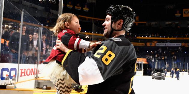NASHVILLE, TN - JANUARY 31: John Scott #28 of the Arizona Coyotes of the Pacific Division All-Stars, 2016 Honda NHL All-Star Game MVP, tends to his daughters after the 2016 Honda NHL All-Star Final Game between the Atlantic Division All-Stars of the Eastern Conference and the Pacific Division All-Stars of the Western Conference at Bridgestone Arena on January 31, 2016 in Nashville, Tennessee. The Pacific Division All-Stars defeated the Atlantic Division All-Stars 1-0. (Photo by Brian Babineau/NHLI via Getty Images)