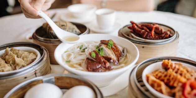 Enjoying noodles and variety of dim sum in Chinese restaurant.