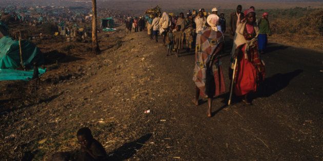 Rwandan Hutu refugees who fled the Tutsi army with little more than the clothes on their back arrive to the Kibumba refugee camp located on the black lava rock of the Nyiragongo volcano. The poor homeless refugees who have walked for days with little to ea