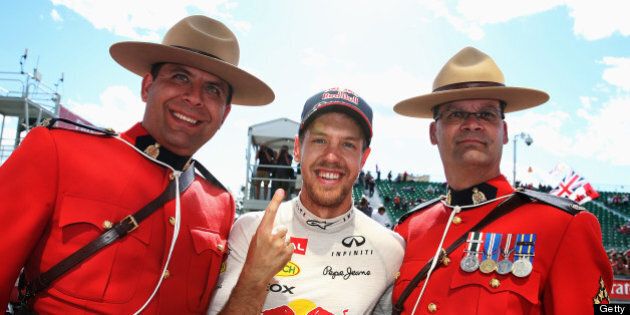 MONTREAL, QC - JUNE 09: Sebastian Vettel of Germany and Infiniti Red Bull Racing celebrates with two Canadian Mounties after winning the Canadian Formula One Grand Prix at the Circuit Gilles Villeneuve on June 9, 2013 in Montreal, Canada. (Photo by Mark Thompson/Getty Images)