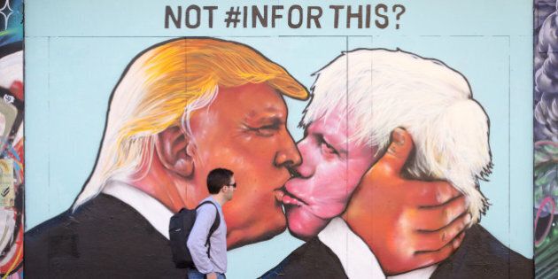 BRISTOL, UNITED KINGDOM - MAY 24: A man passes a mural that has been painted on a derelict building in Stokes Croft showing US presidential hopeful Donald Trump sharing a kiss with former London Mayor Boris Johnson on May 24, 2016 in Bristol, England. Boris Johnson is currently one of the biggest names leading the campaign for Britain to leave the European Union in the referendum which takes place on June 23 and Republican presidential hopeful Donald Trump has also backed a so-called Brexit. (Photo by Matt Cardy/Getty Images)