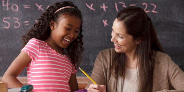 USA, California, Los Angeles, schoolgirl (10-11) and teacher with blackboard in background