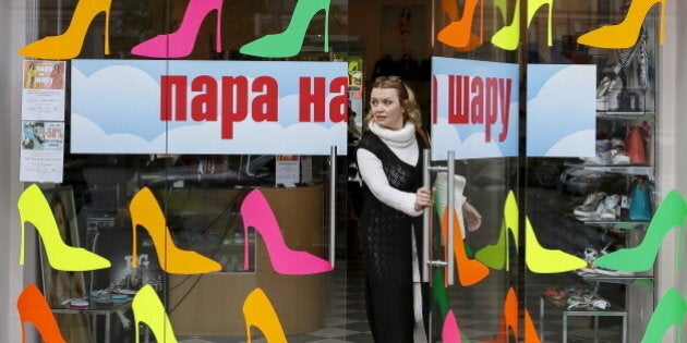 A woman leaves a shoe store in central Kiev, Ukraine, April 25, 2016. An inscription reads: