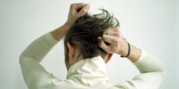 Backview of man pulling his hair