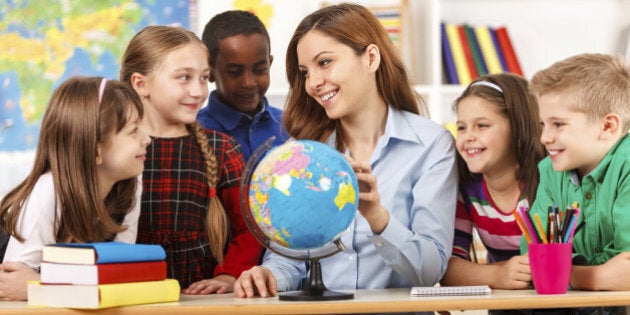 Teacher and children looking at globe