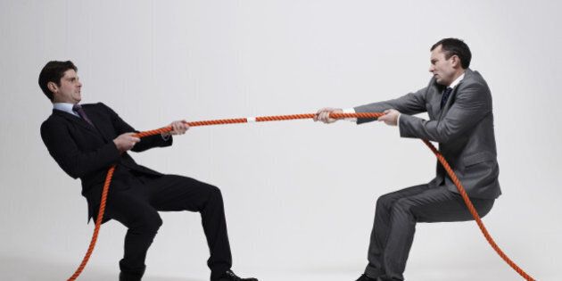 Businessmen playing tug-of-war