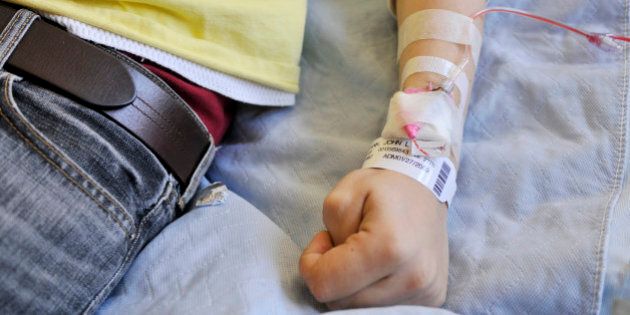 Man lying in bed with IV in arm getting blood transfusion