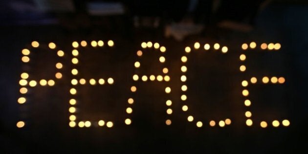 Candles light the word peace as Afghan youths and the Solidarity Party of Afghanistan hold a candlelight vigil for the victims of the Paris terror attacks in Kabul, Afghanistan, Sunday, Nov. 15, 2015. (AP Photo/Rahmat Gul)