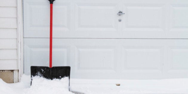 snow shovel leaning up on garage door.