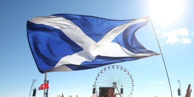 Music fans with a Saltire Flag in front of the Main Stage at the T in the Park music festival held at Balado Park in Kinross, Scotland.