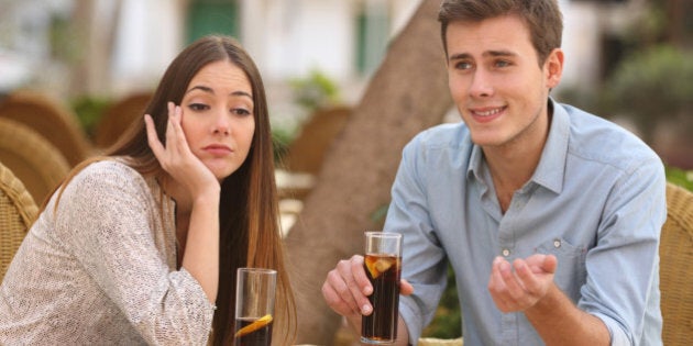 Man and woman dating in a restaurant terrace but she is boring while he speaks