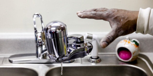 FLINT, MI - JANUARY 21: Fred the handyman at the Shiloh Commons installs a new water filter in a residence January 21, 2016 in Flint, Michigan. The city's water supply had been contaminated by lead after a switch from Lake Huron to the Flint river as a source in April, 2014. At a local fire station, residents were provided with water testing jugs, filters and clean water brought in by the National Guard. Residents also brought in water samples from their homes which would be sent out for lead testing. (Photo by Sarah Rice/Getty Images)