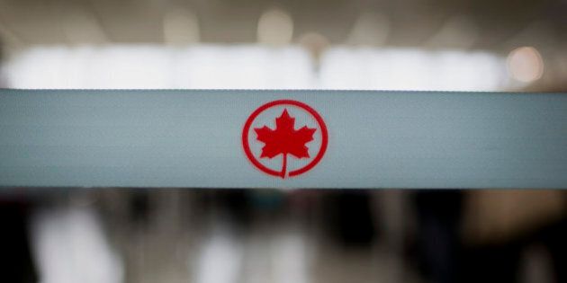 The Air Canada logo is seen on a rope at a check-in counter at Toronto Pearson International Airport in Toronto, Ontario, Canada, on Wednesday, July 3, 2013. Air Canada predicted further pressure on fares this year after its first-quarter yield dropped as competitors added seating and offered lower prices on some routes in North and South America. Photographer: Brent Lewin/Bloomberg via Getty Images