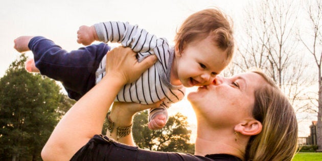 Caucasian mother kissing baby girl outdoors