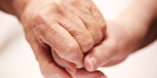 adult helping senior in hospital