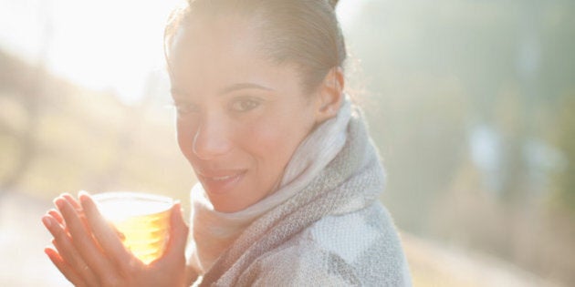 Portrait of smiling woman in scarf drinking cider