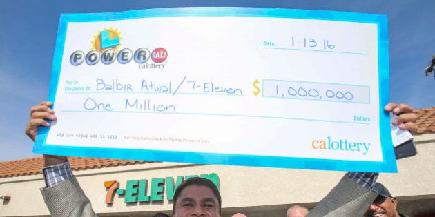 CHINO HILLS, CA- JANUARY 14: Balbir Atwal, owner of the California 7-Eleven that sold one of the 3 Powerball winning tickets, holds up a $1 million check after received from the California State Lottery, in front of his store on January 14, 2016 in Chino Hills, California. Winning tickets were also sold in Florida and Tennessee and will share an estimated record-breaking $1.58 billion dollar jackpot. (Photo by Ringo Chiu/Getty Images)
