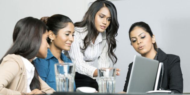 Indian female business colleagues working around a laptop