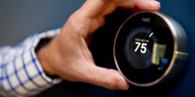 WEST NEWBURY, MA - AUGUST 12: Nick DeLena adjusts his thermostat from Nest Labs in his home on August 12, 2013 in West Newbury, Massachusetts. The simply designed thermostat was created by the Palo Alto, California-based company, Nest. The thermostat tracks your heating patterns and logs them into it's memory to adjust automatically. It is also programmable via smart phone. (Photo by Ann Hermes/The Christian Science Monitor via Getty Images)