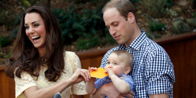 Britain's Kate, the Duchess of Cambridge, and her husband Prince William react as their son Prince George bites a small present that was given to him during a visit to Sydney's Taronga Zoo, Australia Sunday, April 20, 2014. (AP Photo/David Gray, Pool)