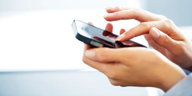 Businesswoman typing on cell phone