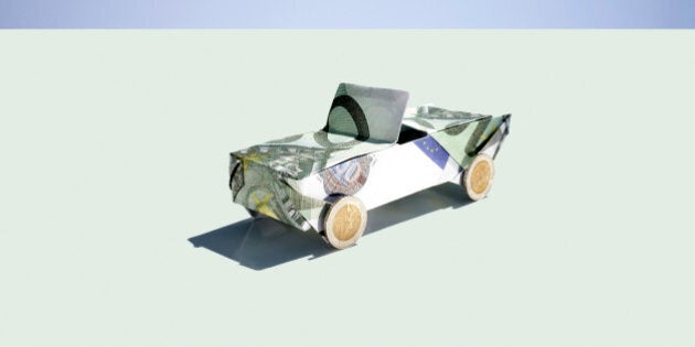 Origami car folded with 100 euro notes and coins