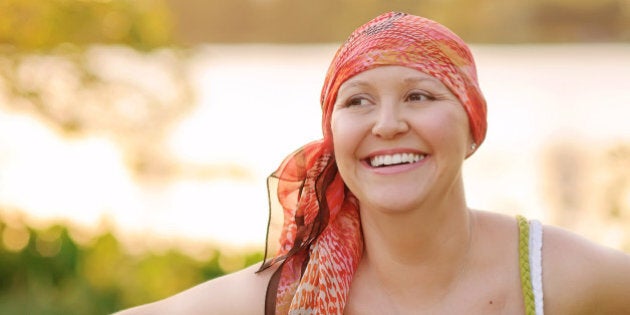 Smiling woman with cancer wearing scarf.