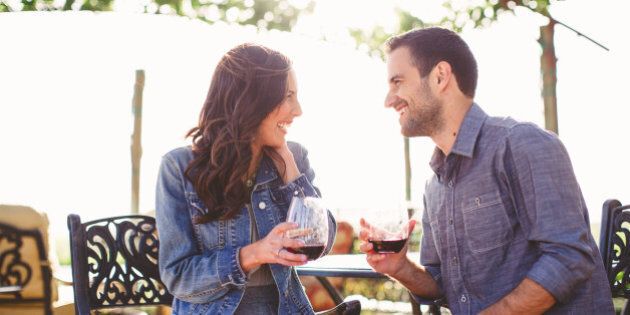 Couple enjoy glasses of wine at outdoor bar
