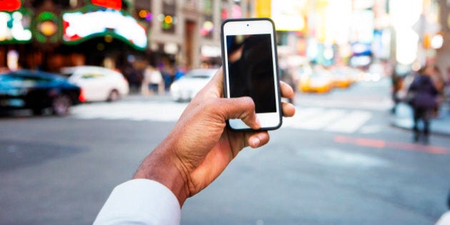 Man holding cellphone in Times Square