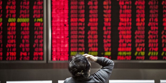 A woman sits in front of electronic boards displaying stock information at a securities brokerage in Beijing, China, on Monday, Jan. 18, 2016. China's economy slowed in December, capping the weakest quarter of growth since the 2009 global recession, as the Communist leadership struggles to manage a transition to consumer-led expansion. Photographer: Qilai Shen/Bloomberg via Getty Images