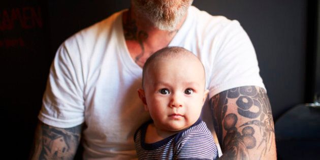 Tattooed father holding his son