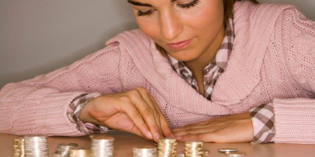 young girl sitting with piles of coins