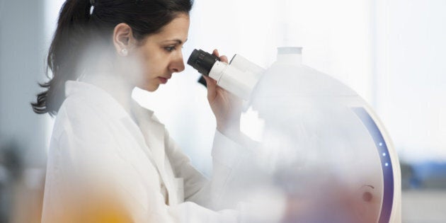 Pakistani scientist using microscope in lab